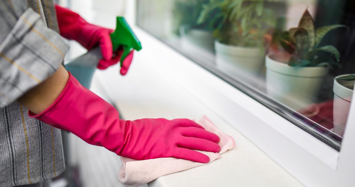 Reinigung eines Fenstersimses mit Sprühflasche und Tuch